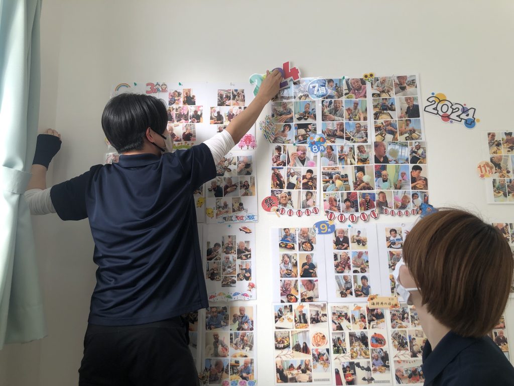 写真を貼りだす管理者と主任