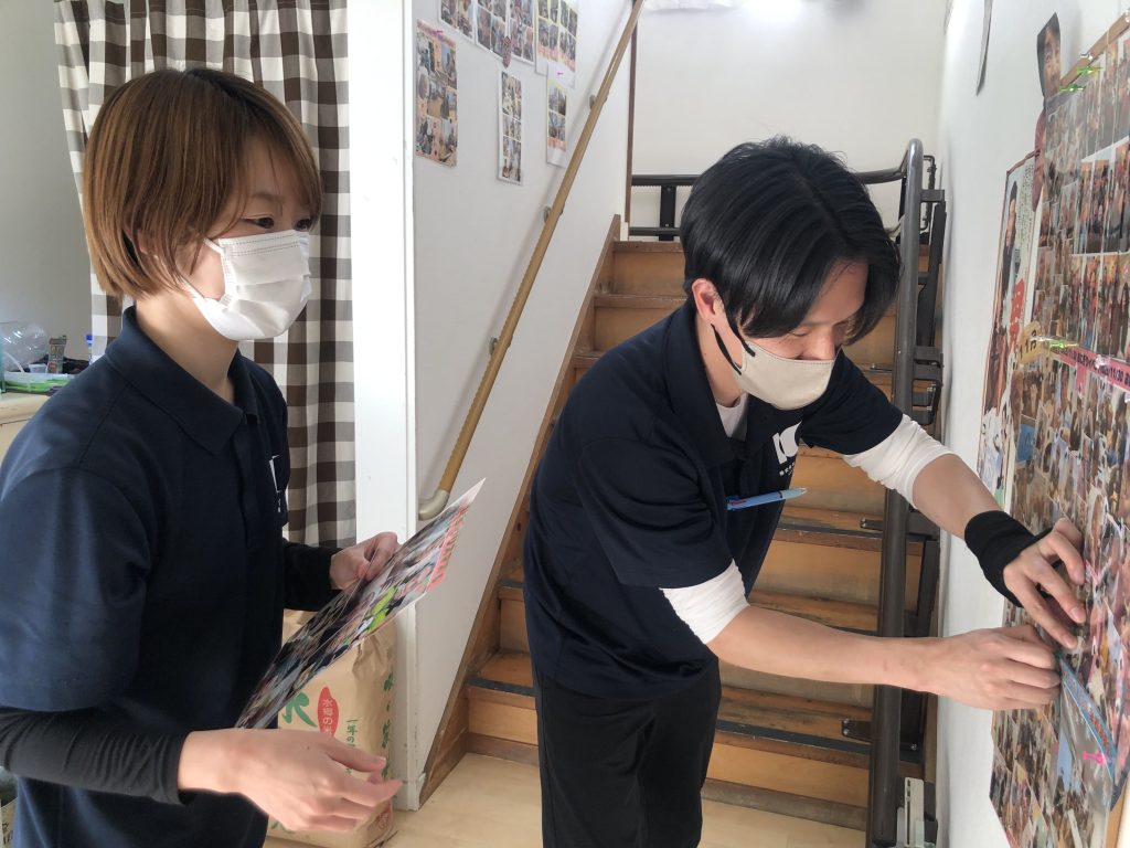 館内の写真を貼りだす管理者と主任